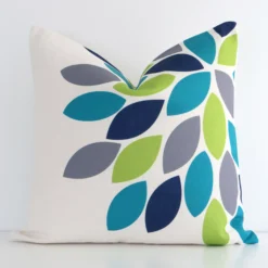 A linen square cushion cover that has a unique patterned design is shown vertically against a white wall. It has a wonderful colourful finish.