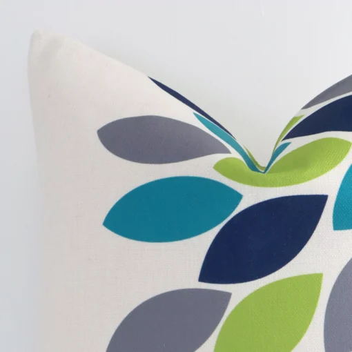 Close up of a linen square cushion in colourful print. The quality of its patterned design is shown in fine detail.