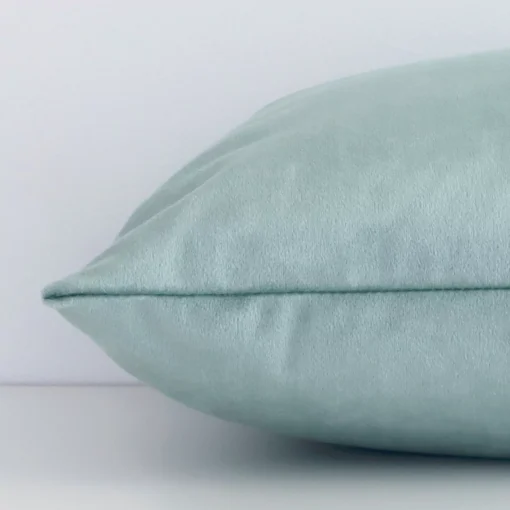 Mint green rectangle cushion cover laid on its back side. It is made of velvet material.