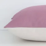 A blush solid-coloured cushion positioned on its back panel. The shot shows a lateral view of the linen fabric and its square size.