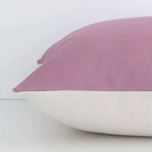 A blush solid-coloured cushion positioned on its back panel. The shot shows a lateral view of the linen fabric and its square size.