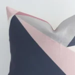 The corner of this linen square cushion cover is shown close up. The geometric design and colourful print are shown in greater detail.