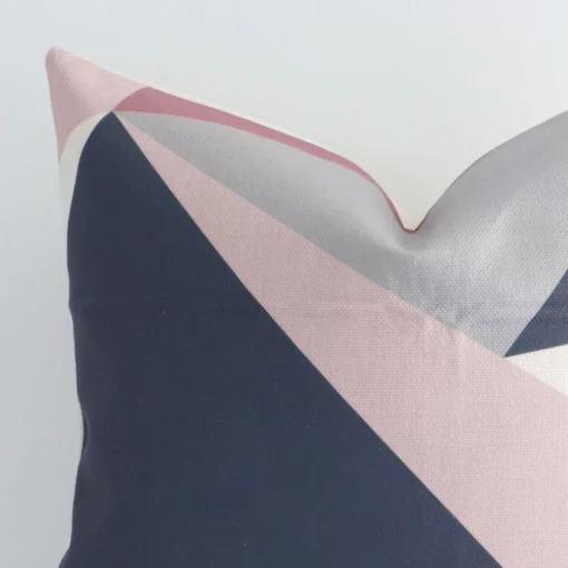 The corner of this linen square cushion cover is shown close up. The geometric design and colourful print are shown in greater detail.