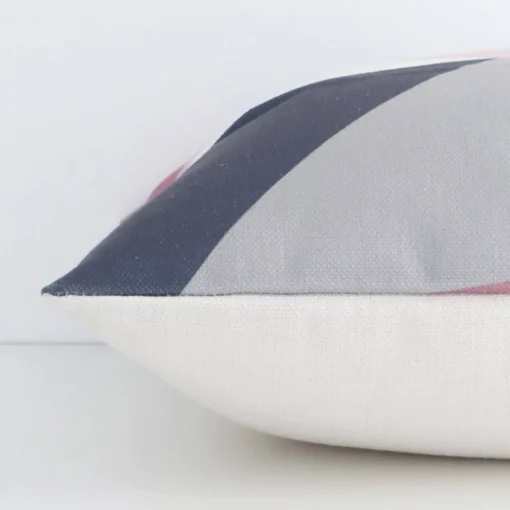 Square colourful cushion laid flat. This view shows the geometric style and linen fabric from side on.