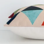 Side edge of geometric square cushion. The linen material and colourful print can be seen from this lateral viewpoint.
