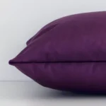 The edge of this velvet rectangle cushion in velvet is shown. The shot shows the front and rear panels.