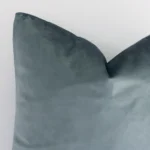 Magnified view of this velvet cushion cover’s corner showing a design and its square size.