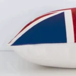 A side view of colourful patterned cushion that has linen fabric and a sqaure shape.