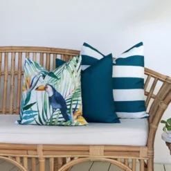 Outdoor living area with a rattan seat that is showcasing a set of 3 Byron toucan couch cushions.