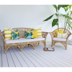 Beautiful set of 7 yellow couch cushions on rattan seats in a bright outdoor living area.