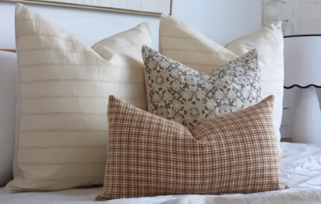 Arrangement of designer cushions styled in a light room.