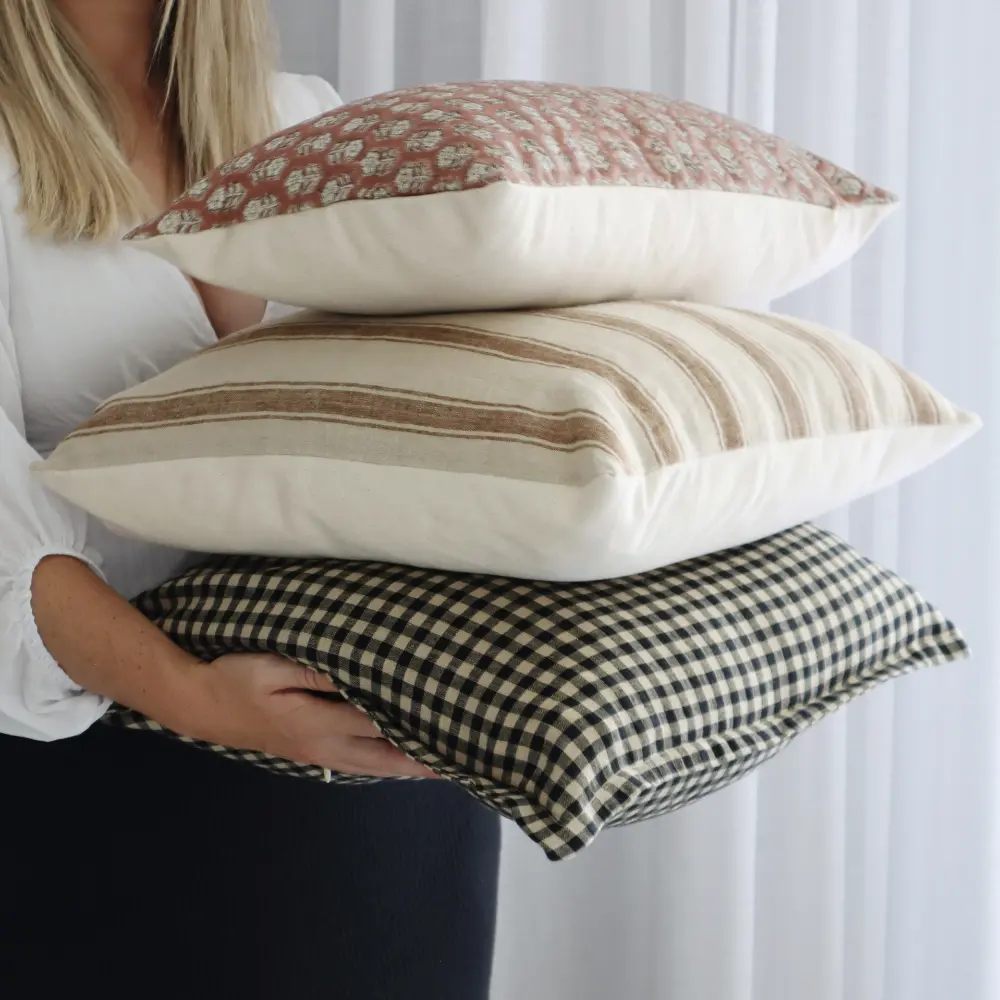 An expert stylist is selecting a cushion set that is composed of different designs.