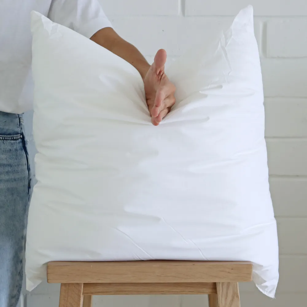A hand is chopping into a quality large insert placed on a wooden stool.
