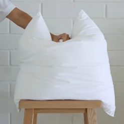 An insert being squashed from above by a hand showing its plumpness.