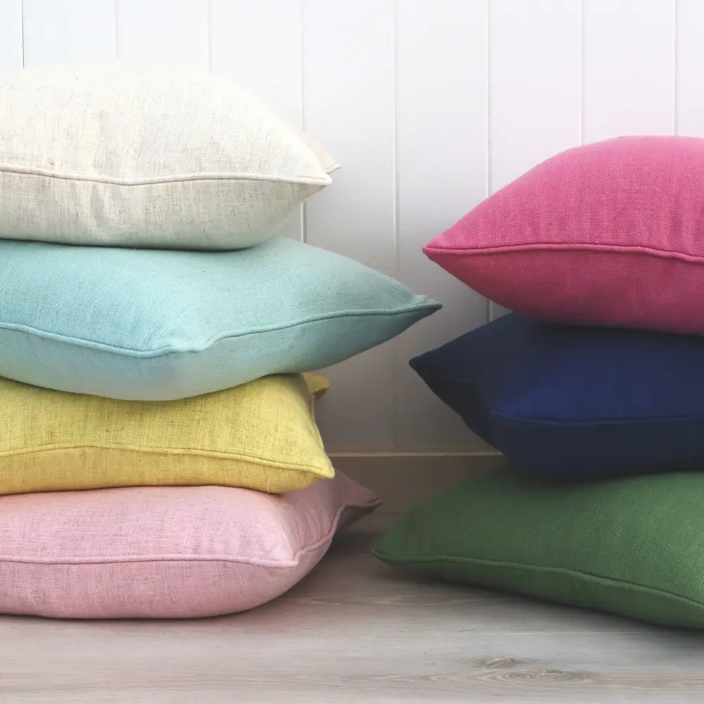 Multiple colours of polyester cushions in two tower arrangements.
