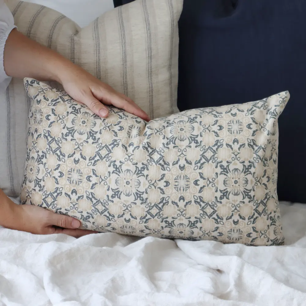 A Thai block printed designer cushion being placed at the front of a collection.