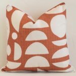 Precision shot of this square rust cushion cover. It is possible to see the geometric style and outdoor fabric in greater depth.