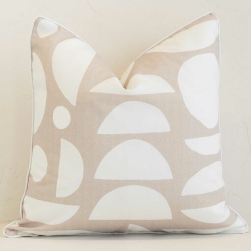 Sand geometric cushion cover in front of a white wall. It has a square shape and is made from an outdoor material.