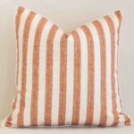 An eye-catching outdoor square cushion cover featuring a hue that is rust. It has a unique stripe style.