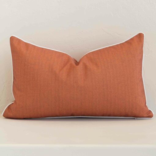A graceful rectangle rust cushion with a solid-coloured style on durable outdoor fabric.
