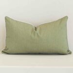 A bold solid-coloured outdoor cushion in a sleek rectangle size with a sage tone of colour.