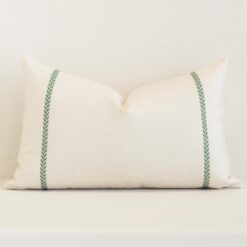A pretty striped outdoor cushion cover is shown against a brick wall. It features a rectangle shape and a cream colour finish.