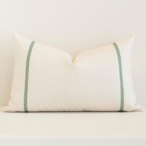 A pretty striped outdoor cushion cover is shown against a brick wall. It features a rectangle shape and a cream colour finish.