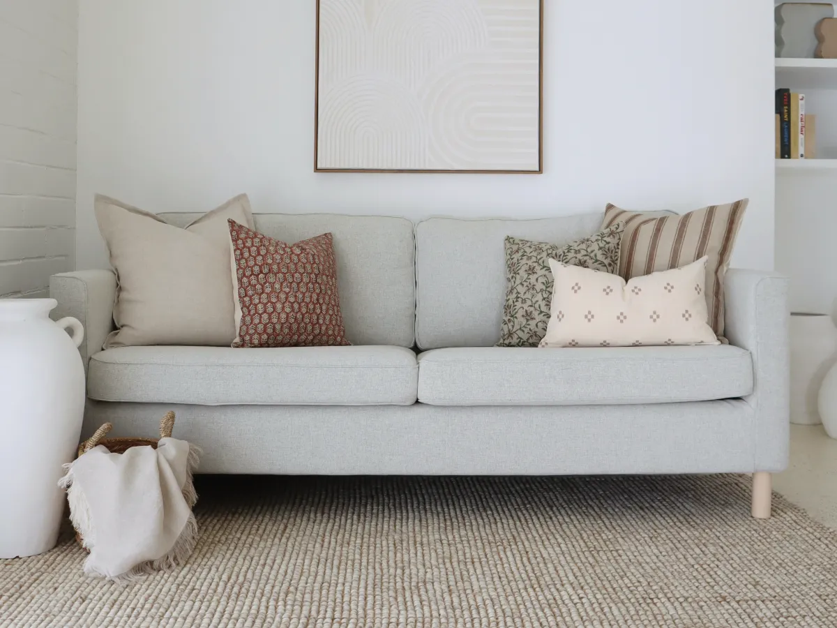 A coordinated collection of cushions featuring various patterns on a light coloured sofa.