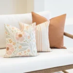 A white sofa showing a set of 3 desert bloom outdoor sofa cushions.
