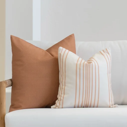 A set of Desert Bloom outdoor cushions tucked in the corner of a white sofa.