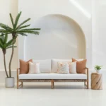 A wooden couch with a set of 5 desert bloom outdoor sofa cushions arranged neatly on it.