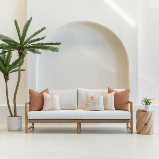 A wooden couch with a set of 5 desert bloom outdoor sofa cushions arranged neatly on it.