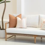 Outdoor living room with 3 desert bloom coloured outdoor cushions on a sofa.