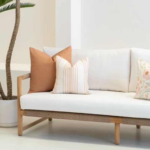 Outdoor living room with 3 desert bloom coloured outdoor cushions on a sofa.