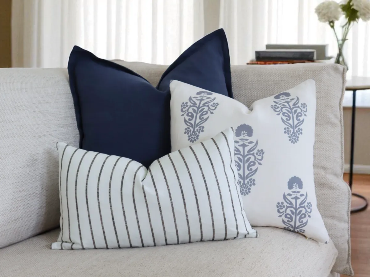 Maya cushions on a sofa which demonstrate the solid + stripe + floral formula in action.