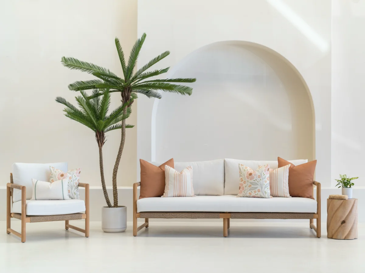 An outdoor lounge and armchair are shown styled with terracotta outdoor cushion arrangements.