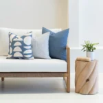 Living room scene with 3 outdoor couch cushions on a sofa.