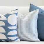 A set of 3 pacific blue coloured outdoor sofa cushions sit on outdoor seating.