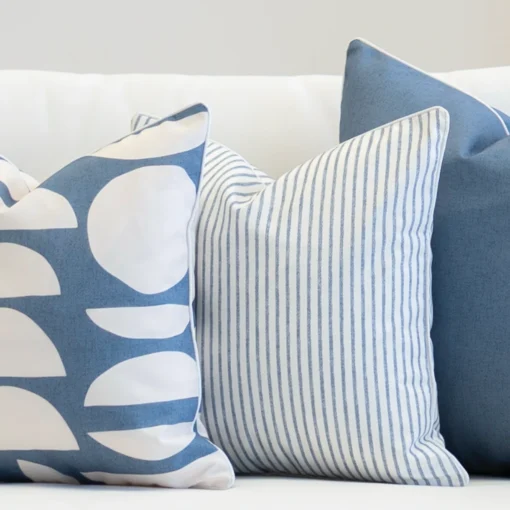 A set of 3 pacific blue coloured outdoor sofa cushions sit on outdoor seating.