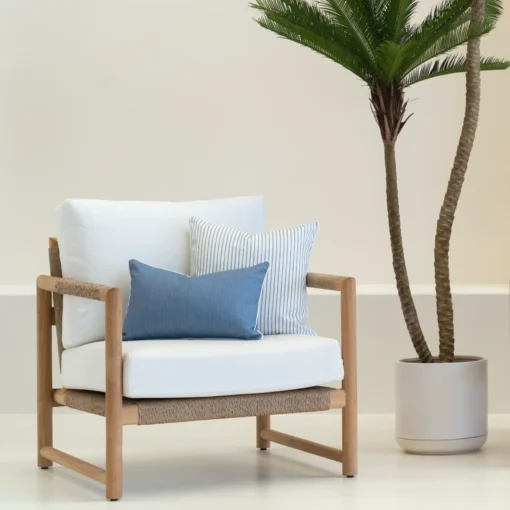 2 pacific blue coloured outdoor cushions are arranged on a single-seater chair.