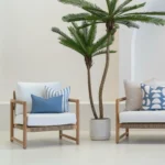 Outdoor seating showing 4 outdoor cushions in a pacific blue colour on a wooden sofa.