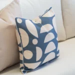 2 pacific cove outdoor cushions are displayed on a white sofa.