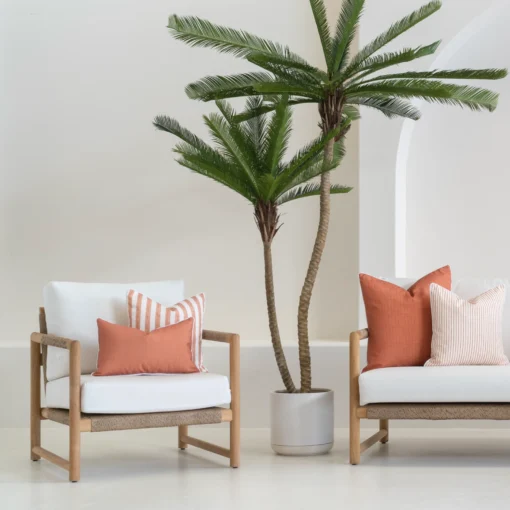 A white outdoor living room showing 4 pacific rust outdoor cushions displayed on a sofa.