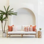 A white sofa is styled with a set of 5 pacific rust outdoor sofa cushions.