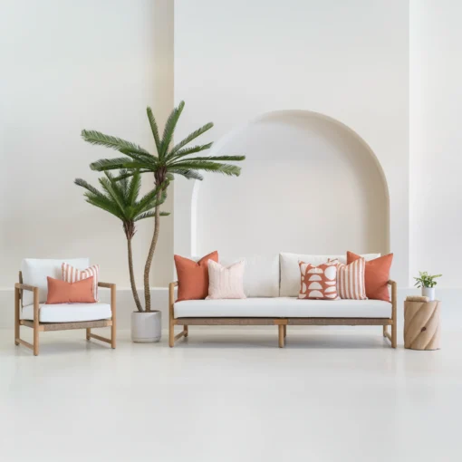 A white sofa is styled with a set of 7 pacific rust outdoor sofa cushions sitting on it.