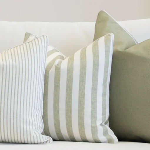 3 outdoor couch cushions in a pacific sage colour sitting on a white couch.