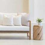 A white couch with a set of 3 outdoor couch cushions in a pacific sand colour.