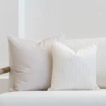 Outdoor seating showcasing a set of 2 pacific sand coloured outdoor cushions on a white sofa.