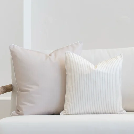 Outdoor seating showcasing a set of 2 pacific sand coloured outdoor cushions on a white sofa.