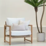 A wooden armchair displaying 2 pacific sand outdoor cushions.
